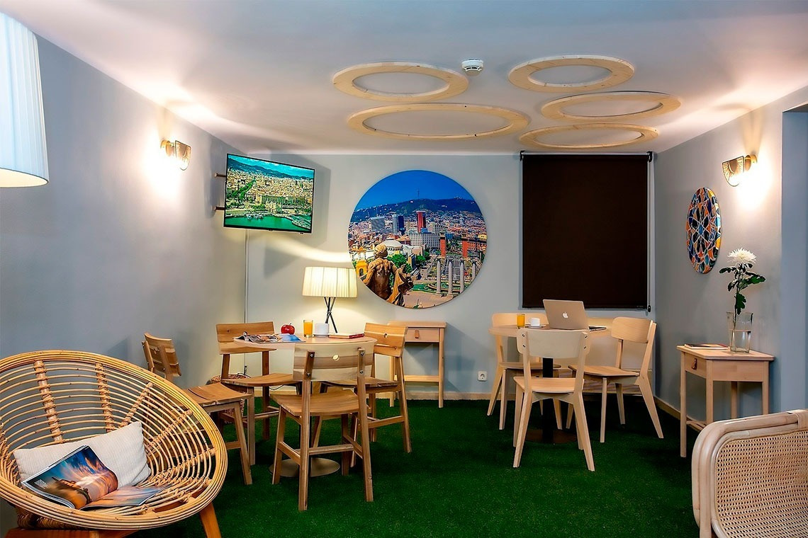 una habitación con mesas y sillas y una pintura de una ciudad en la pared