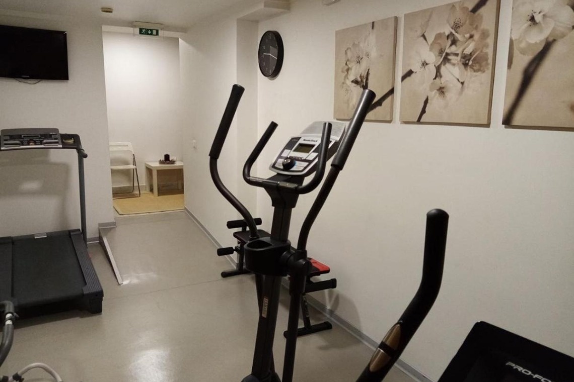 un reloj en la pared de un gimnasio junto a una cinta de correr pro-fc