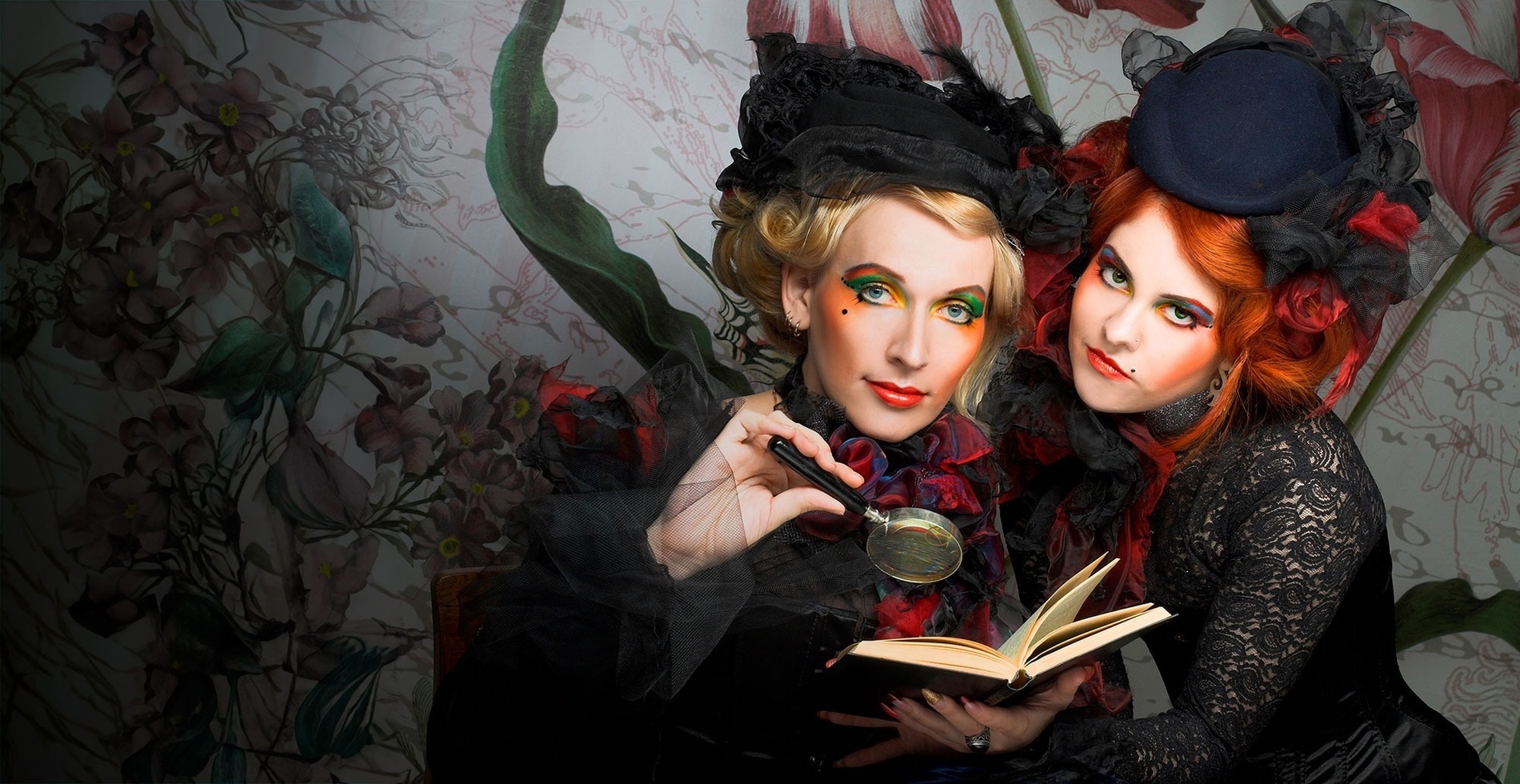a woman holding a magnifying glass next to another woman