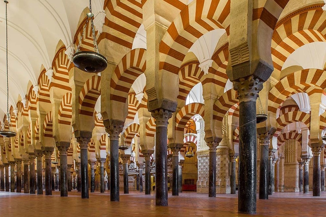 una habitación llena de columnas y arcos en una mezquita