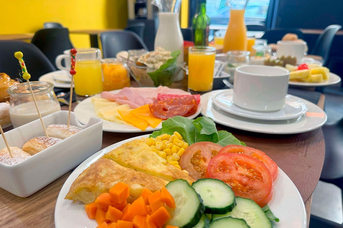 a table topped with plates of food and drinks including orange juice