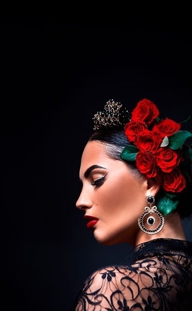 una mujer con una corona y rosas rojas en el pelo .