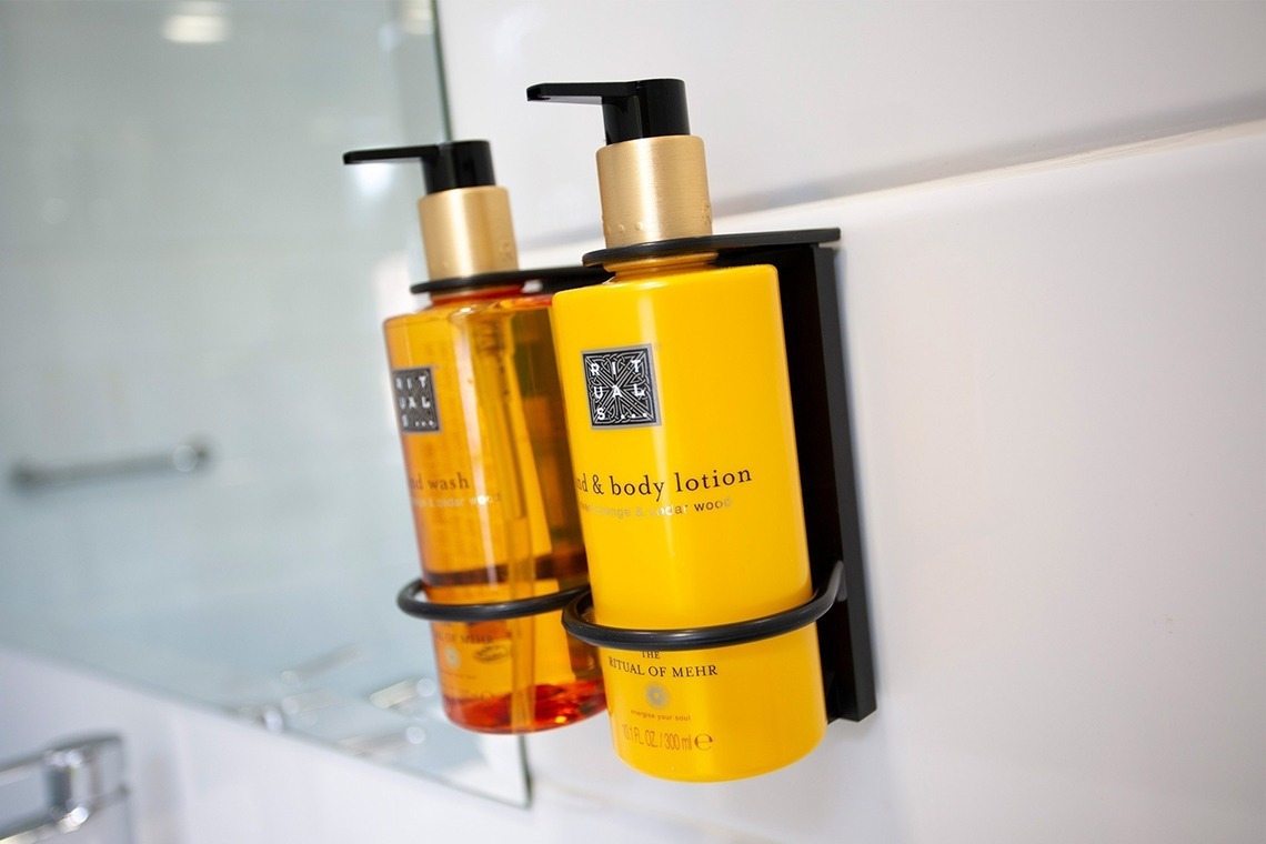two bottles of ritual of mehr lotion are hanging on a wall