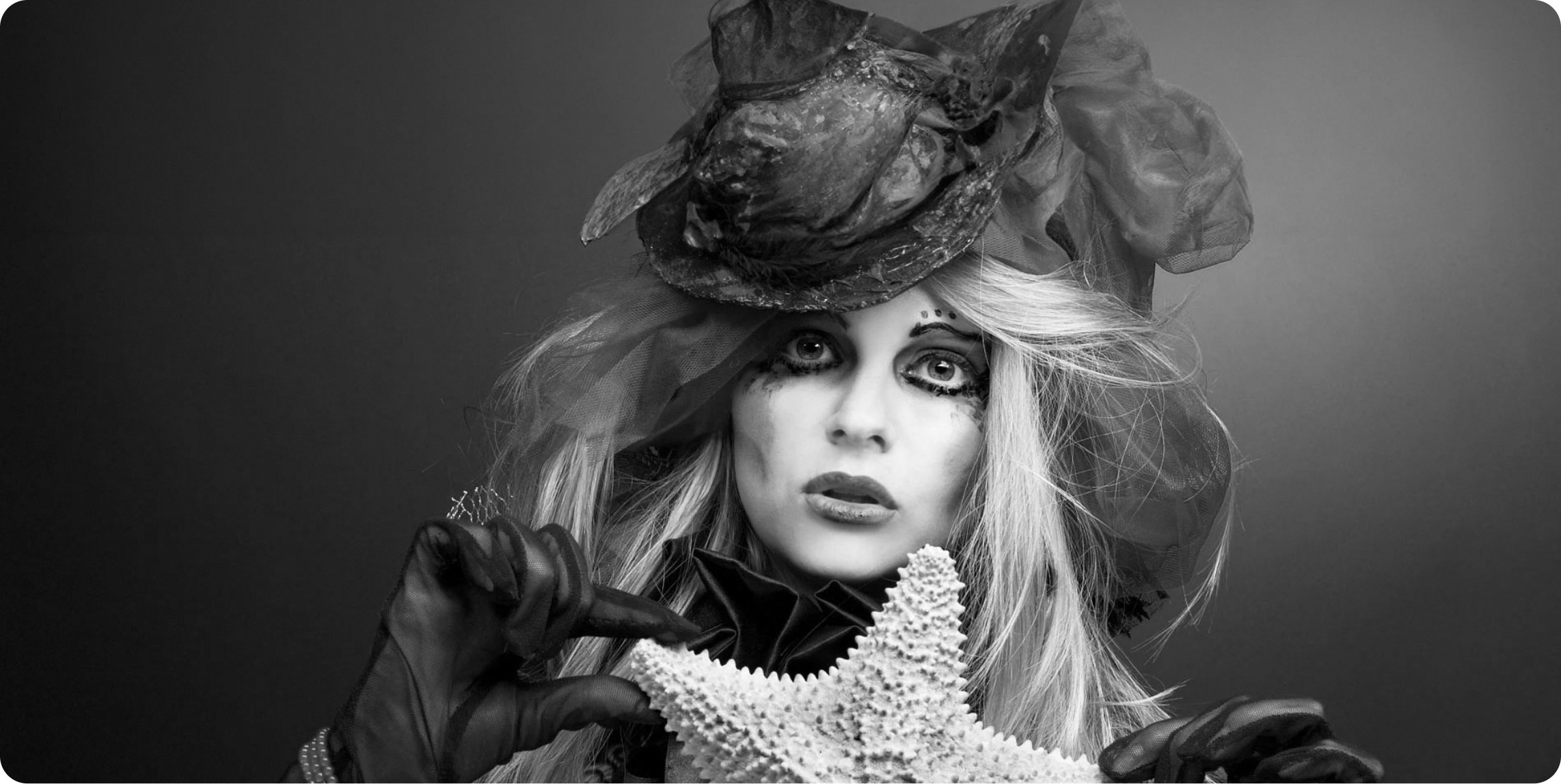 une femme portant un chapeau rouge tient une étoile de mer