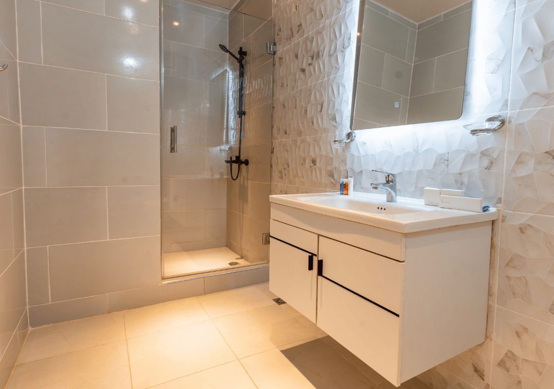 Baño moderno con ducha y lavabo suspendido, ideal para Casual: Eden Bayahibe.