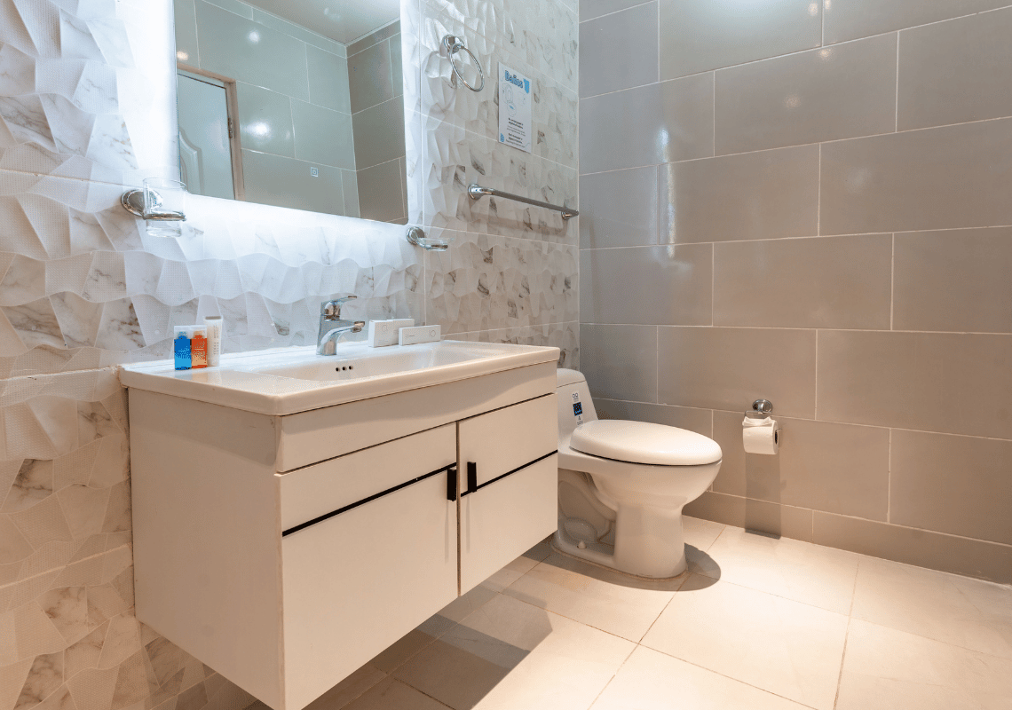 Baño moderno con lavabo, inodoro y espejo, perfecto para tu estancia en Casual: Eden Bayahibe.
