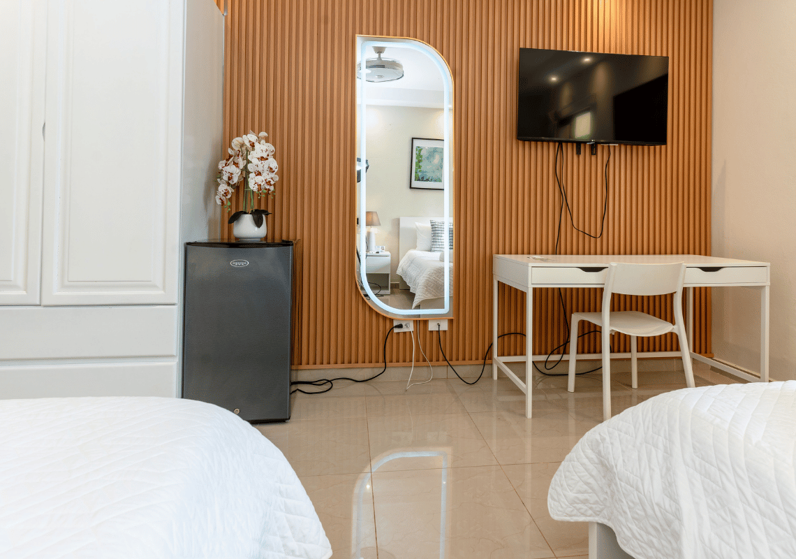 Habitación moderna con TV, espejo LED, escritorio y mini-nevera, ideal para tu Casual: Eden Bayahibe.