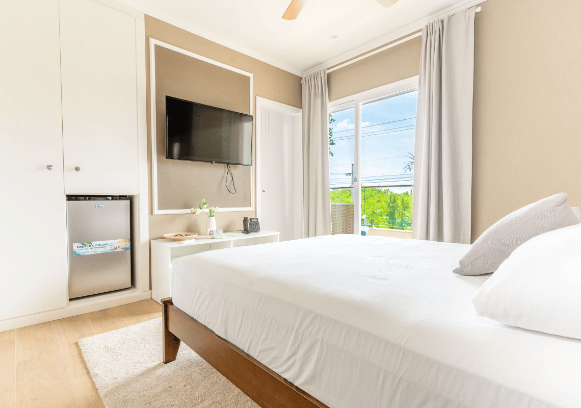 Cama de hotel confortable con Casual: Green Village Bayahibe, TV y vista al exterior.