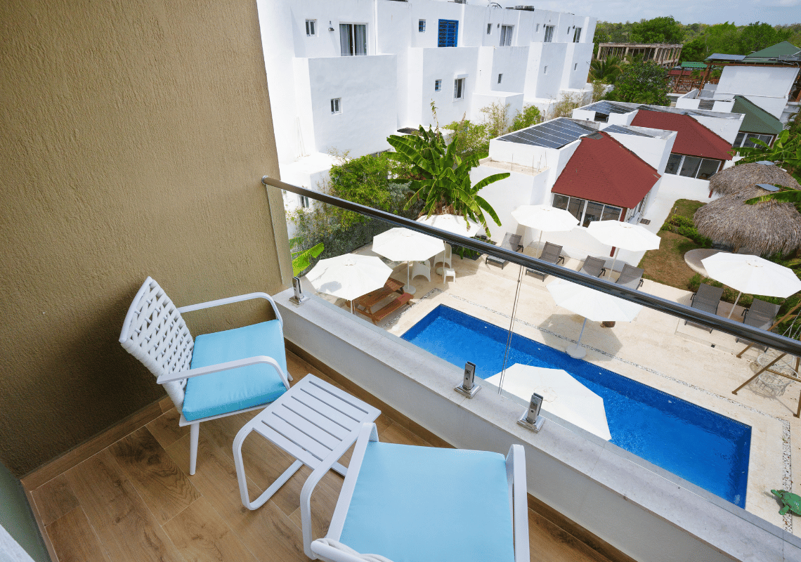 Balcón con vista a piscina y tumbonas de hotel. Ambiente tropical. Casual: Green Village Bayahibe