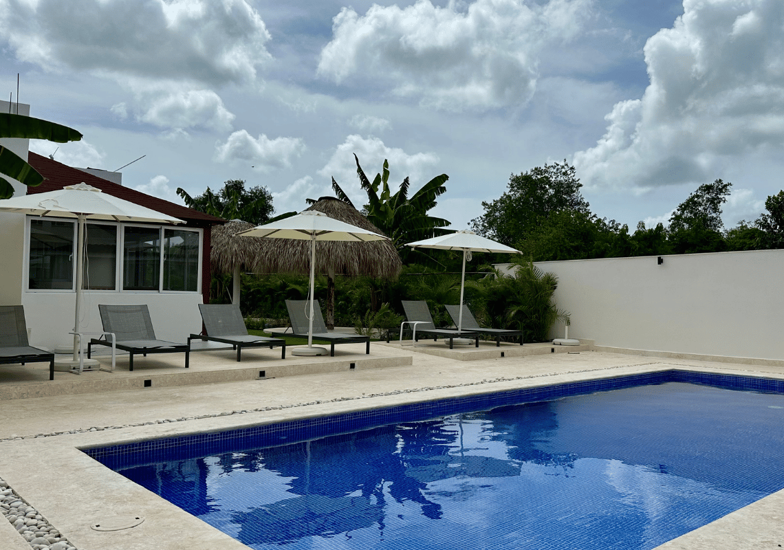 Casual: Green Village Bayahibe : Piscine et chaises longues à l'extérieur d'un hôtel tropical sous un ciel nuageux.