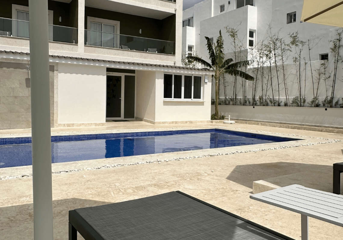 Piscine bleue étincelante et chaises longues dans un complexe hôtelier moderne Casual: Green Village Bayahibe.