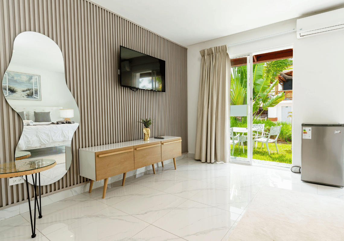 Habitación moderna con TV, espejo, mini-nevera y vista a jardín tropical. Casual: Green Village Bayahibe