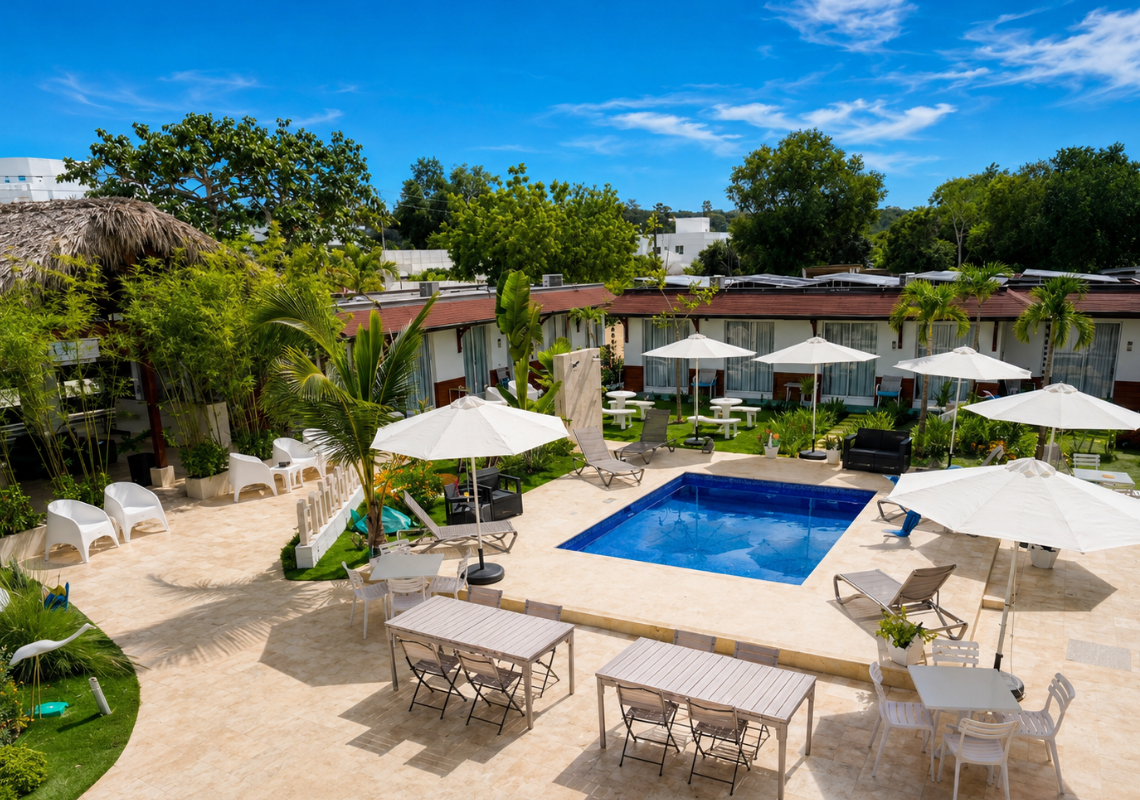 Hôtel avec piscine, parasols et terrasses. Casual: Green Village Bayahibe ensoleillé.