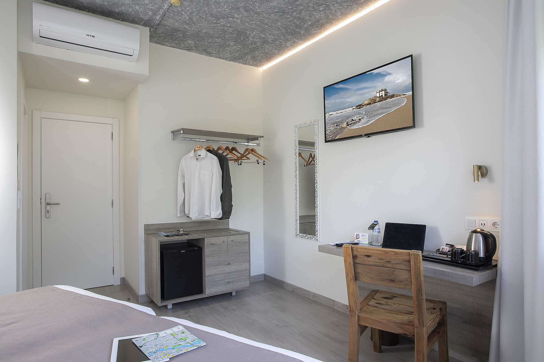 Habitación de hotel moderna con TV Casual: Inca Porto, minibar y un interior acogedor.