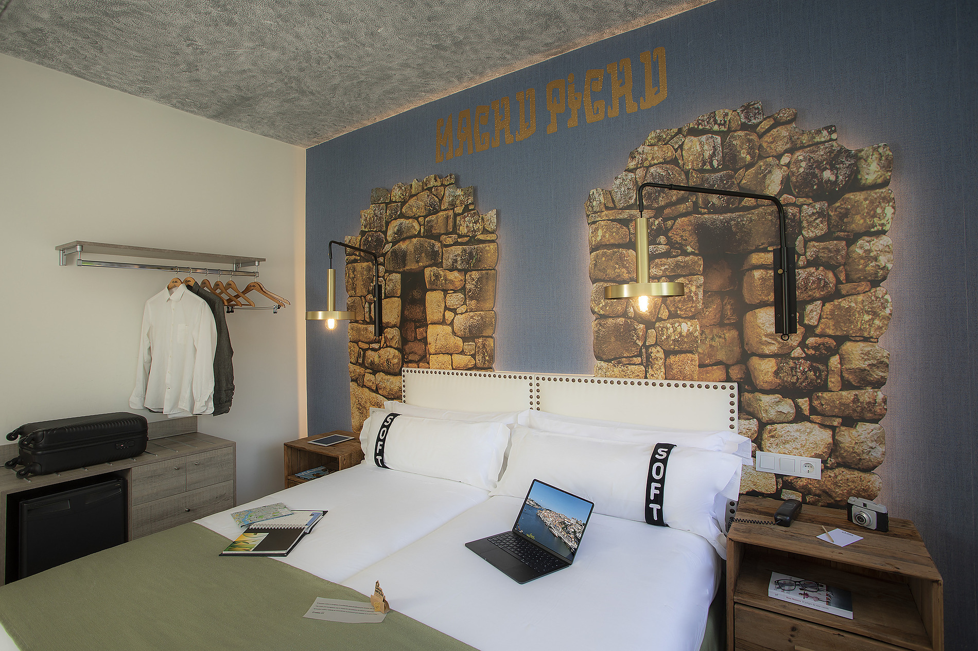 Cama cómoda en habitación temática de Casual: Inca Porto con mural rústico y comodidades modernas.