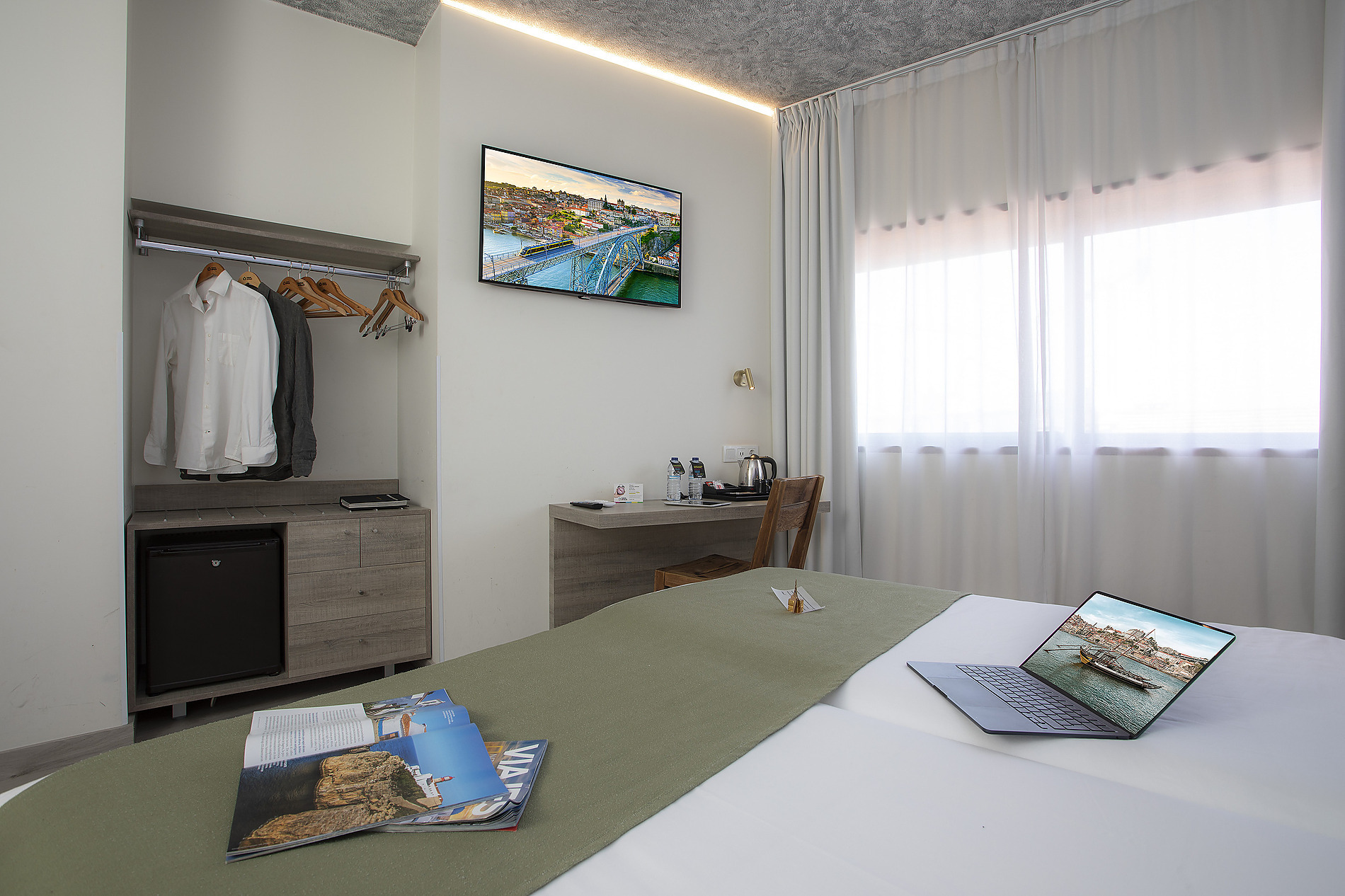 Habitación de hotel moderna con Casual: Inca Porto, TV, mini-nevera y cama cómoda.