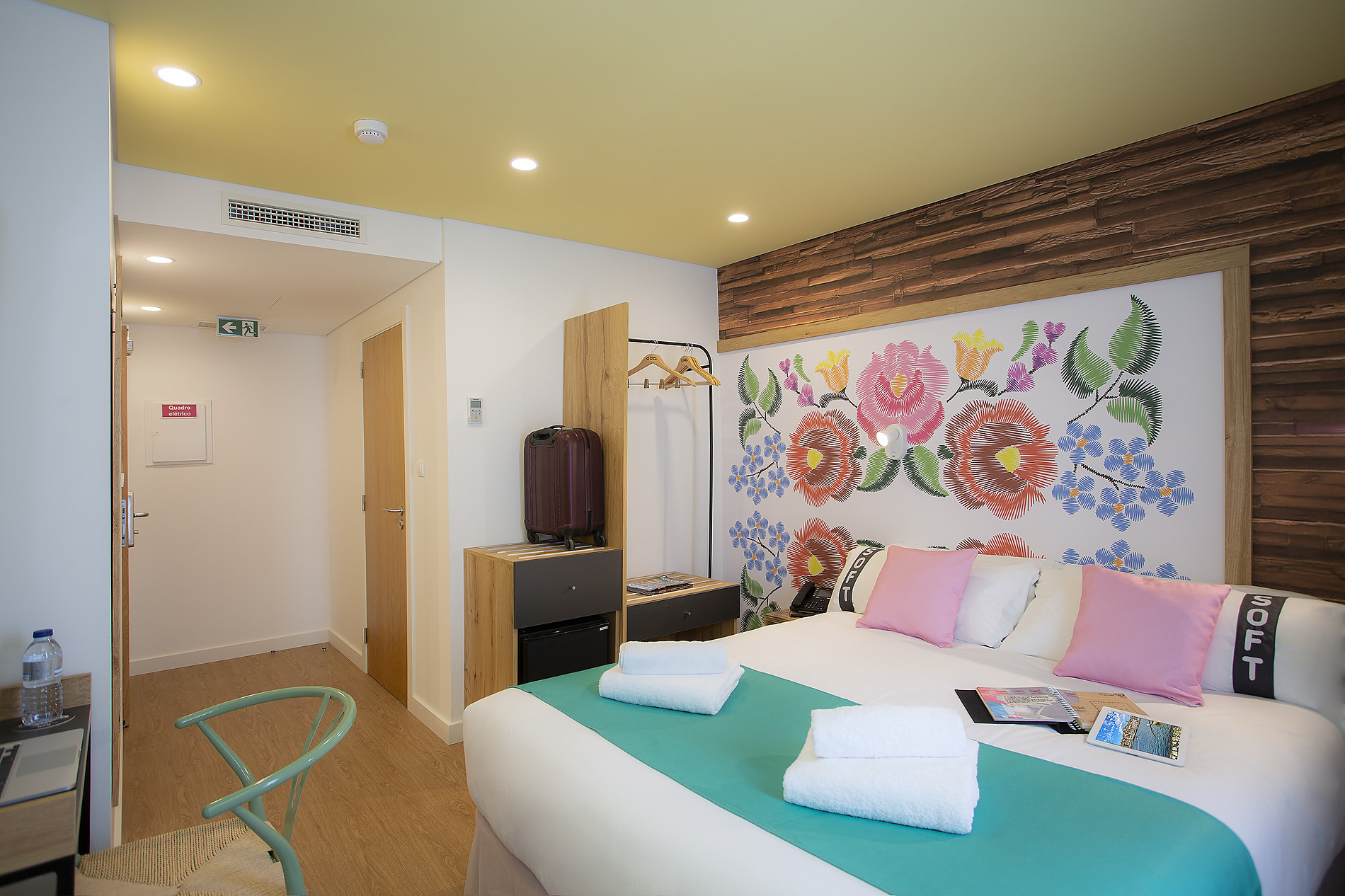Habitación de hotel con cama confortable, decoración floral y estilo moderno. Casual: Raizes Porto.