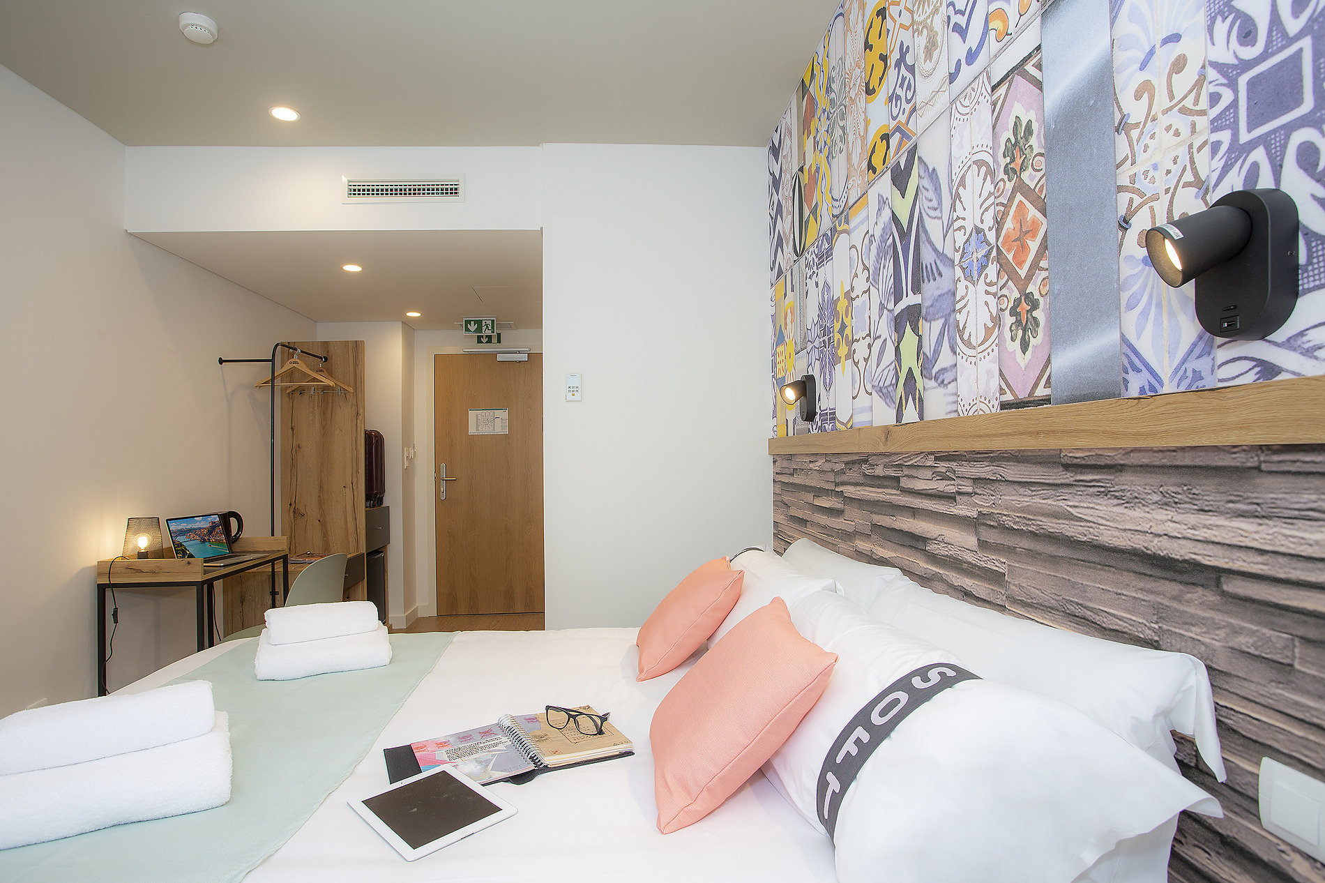 Habitación moderna con cama cómoda, escritorio y decoración Casual: Raizes Porto.