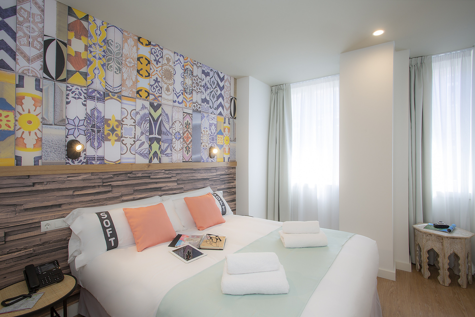 Cama matrimonial con almohadas color coral y diseñoCasual: Raizes Porto de azulejos vibrantes.