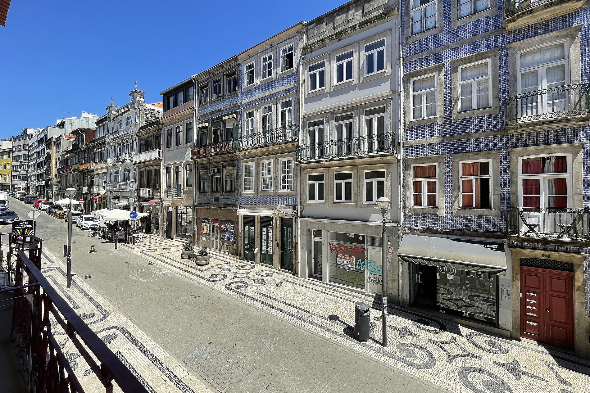 Edificio hotelero con fachadas de azulejos azules y balcones, calle adoquinada con Casual: Raizes Porto.