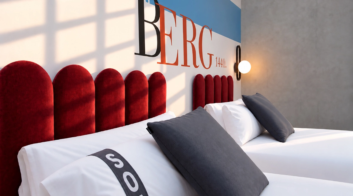Camas gemelas con cabeceros de terciopelo rojo y almohadas grises en una habitación de hotel moderna con arte en la pared. Casual Vintage