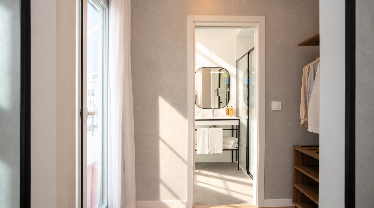 Interior de hotel elegante con vista, baño moderno y closet Casual Vintage.