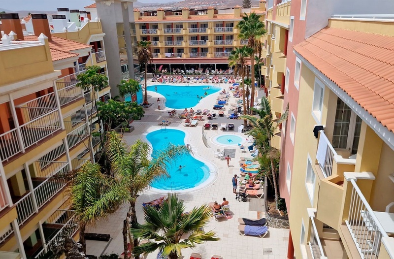 una gran piscina rodeada de palmeras y edificios