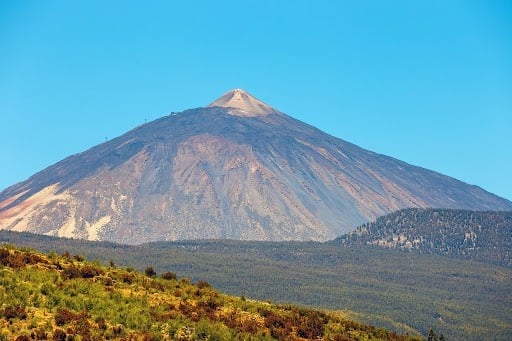a large mountain with a blue sky in the background