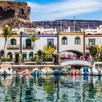 a group of boats are docked in a harbor with buildings in the background .