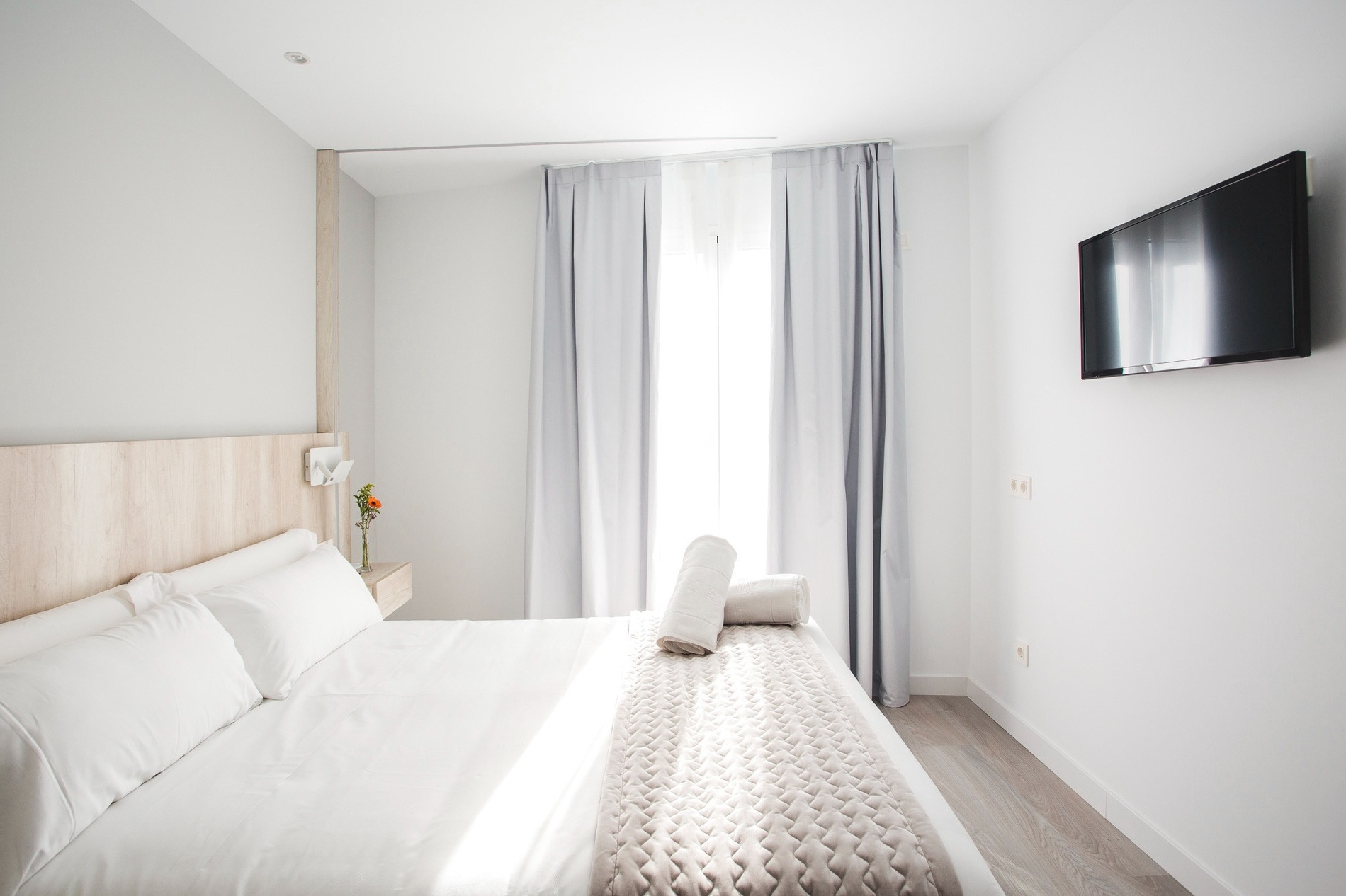 una habitación blanca con una cama y una televisión