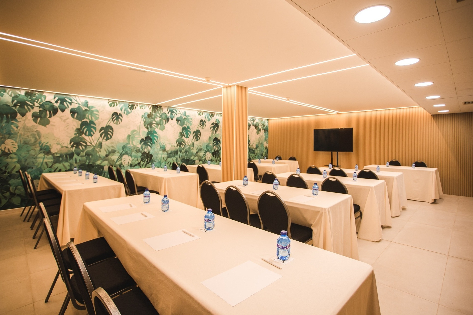 una sala de conferencias con mesas y sillas y botellas de agua