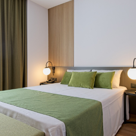 una cama con una manta verde y almohadas verdes