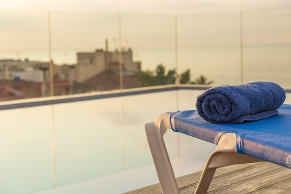 una toalla azul está enrollada en una silla junto a una piscina