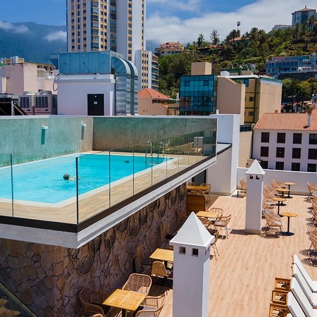 a man is swimming in a pool on the roof of a building