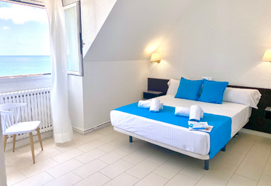 una habitación con una cama y una ventana con vista al océano