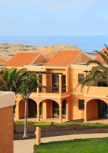 Building with orange roof and ocean view. Checkin: Corporate.
