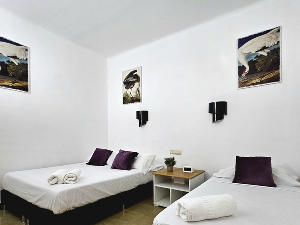 una habitación con dos camas y dos cuadros en las paredes