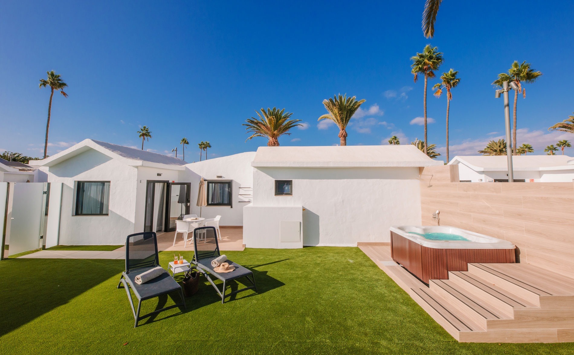 una casa blanca con un jacuzzi en el patio