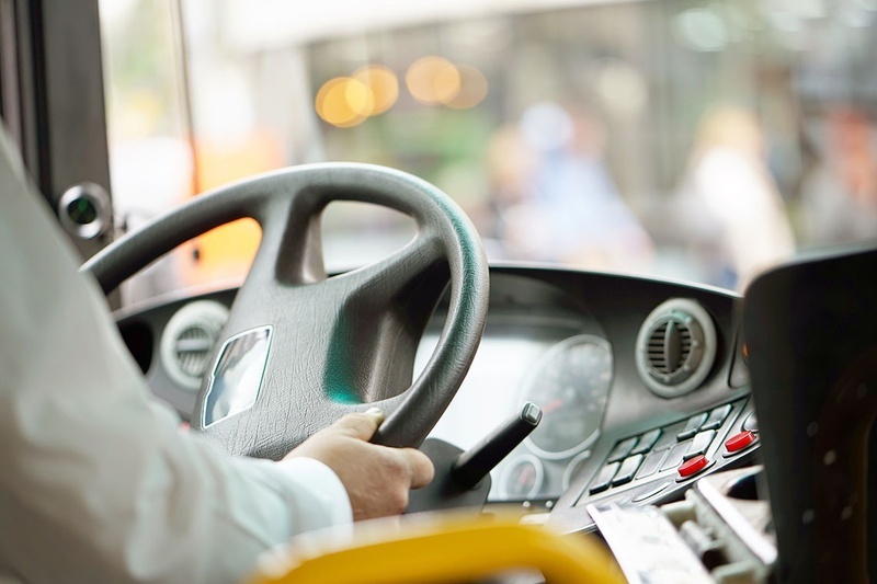 un hombre sostiene el volante de un autobús mientras conduce