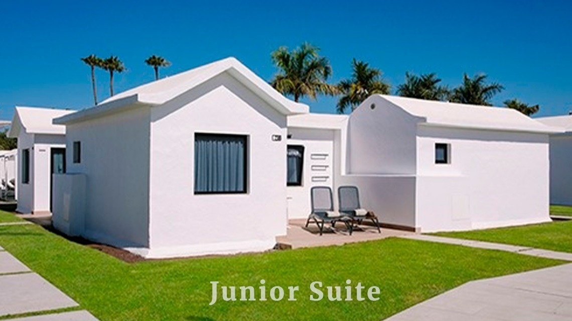 una suite junior se muestra al lado de una casa blanca