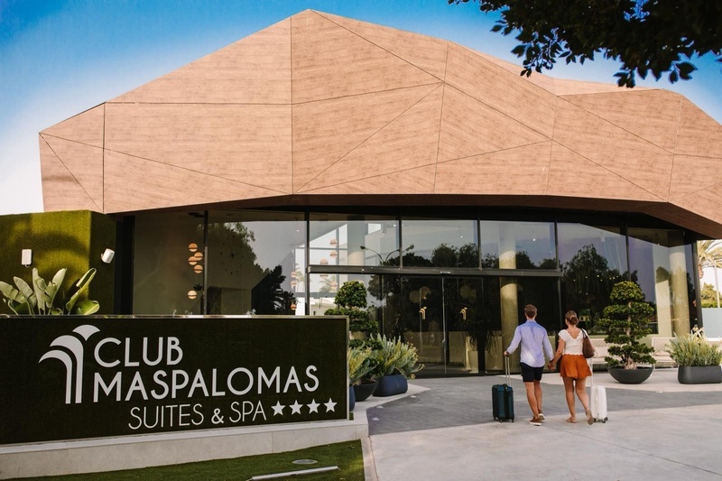 Gelukkig stel bij Club Maspalomas, reizend met bagage.