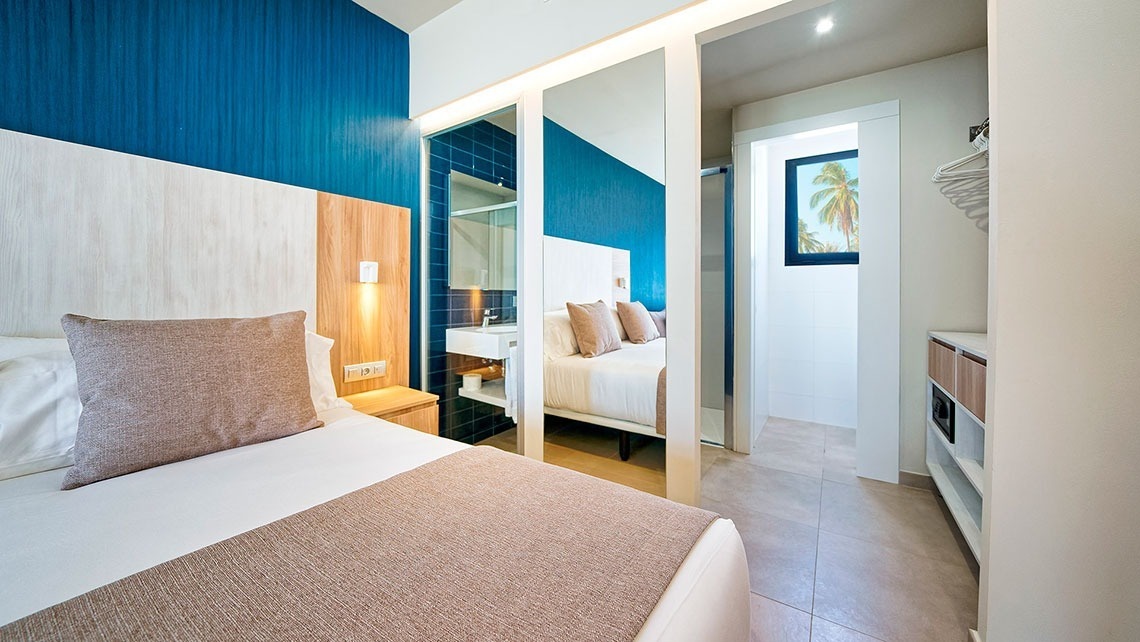 una habitación de hotel con una cama y un espejo