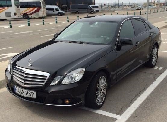 una camioneta mercedes con las puertas abiertas está estacionada en un estacionamiento