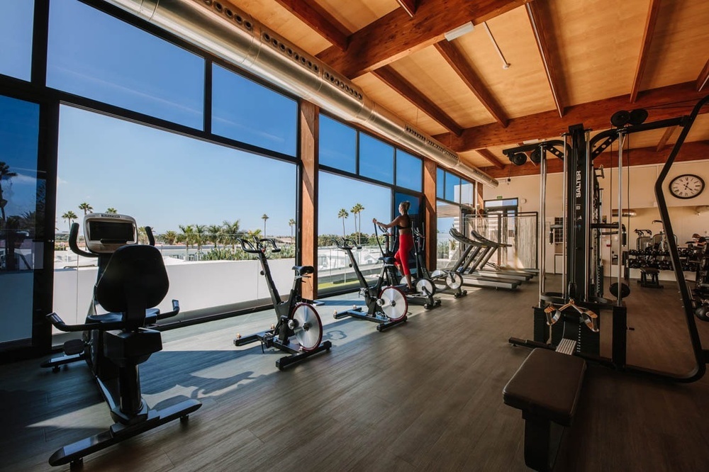 un gimnasio con muchas ventanas y un reloj en la pared