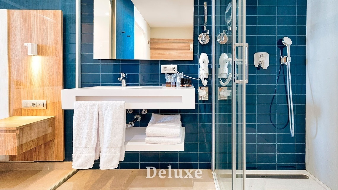 a bathroom with blue tiles and the word deluxe on the bottom