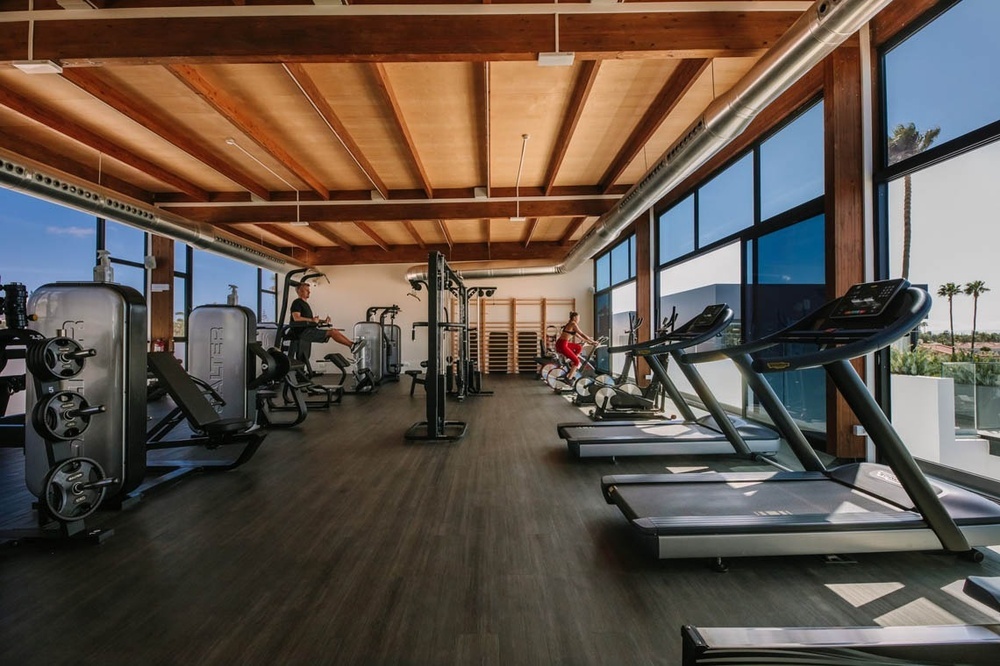 un gimnasio con muchas máquinas y una cinta de correr con la palabra technogym en la parte superior