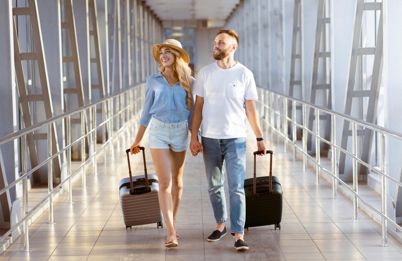 dos mujeres en trajes de baño corriendo por la playa con anillos inflables
