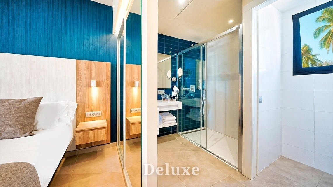 una habitación con una cama y un baño con la palabra deluxe al fondo