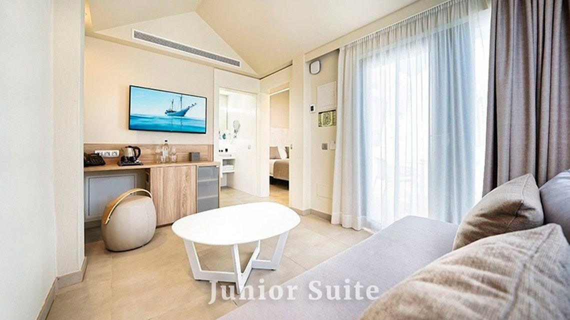 a junior suite with a couch and a table