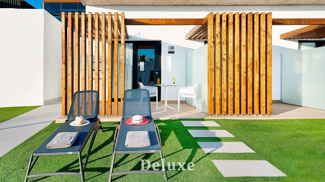 dos tumbonas están frente a una casa con la palabra deluxe al fondo